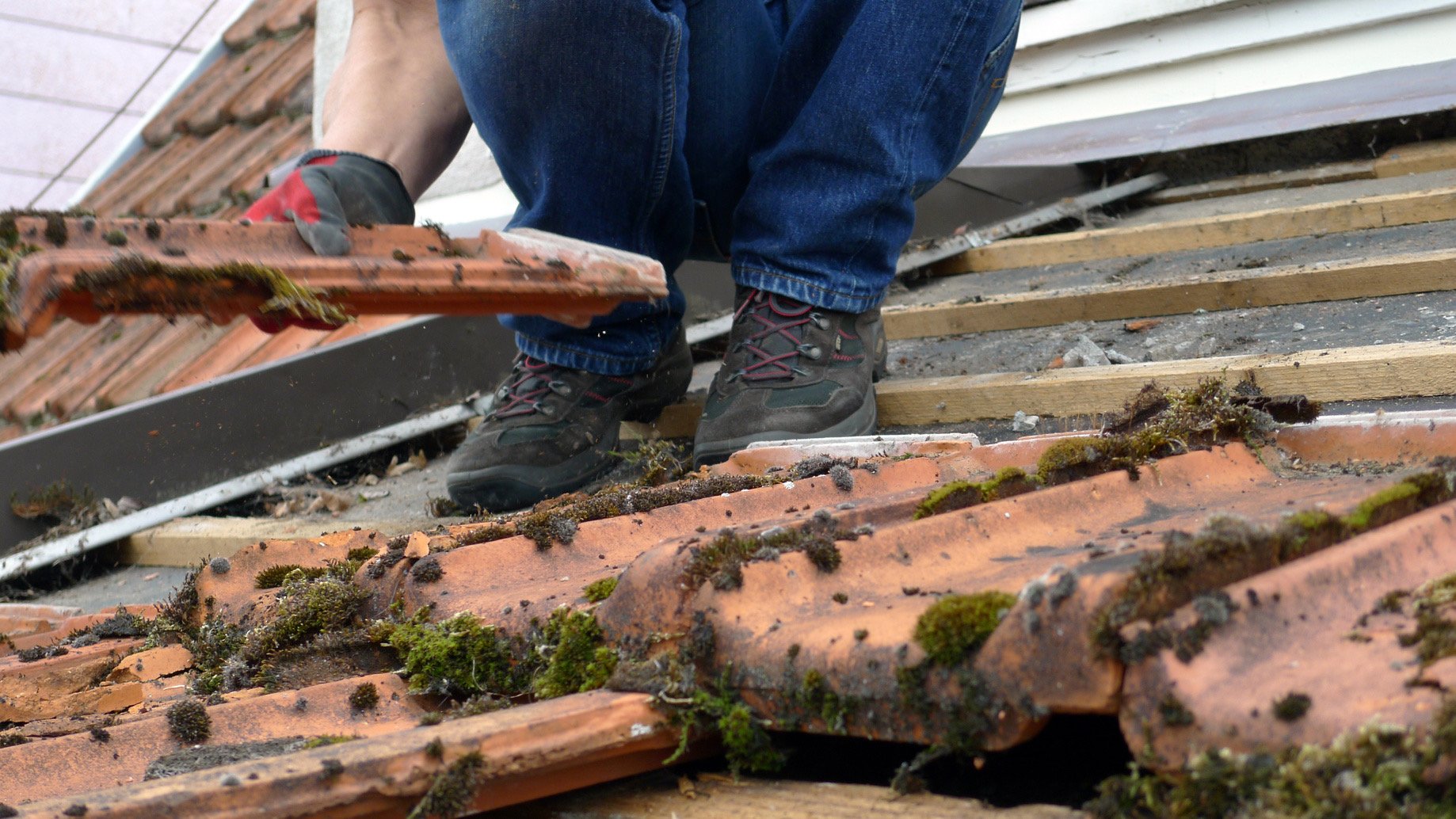 Artisan couvreur en intervention pour remplacer des tuiles